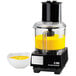 A Waring commercial food processor with a bowl of yellow liquid.