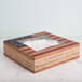 A 9" x 9" x 2 1/2" bakery box with a window and vintage American flag design on the counter.
