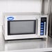 A silver Vollrath commercial microwave with blue buttons and a digital screen.