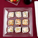 A WNA Comet clear square plastic plate with sushi rolls on it.