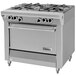 A stainless steel Garland gas range with four burners on a counter in a professional kitchen.