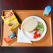 An orange Cambro dietary tray with a sandwich, chips, and a drink on it.