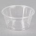 A clear plastic Fabri-Kal Greenware portion cup on a gray surface.