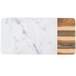 A rectangular white melamine serving board with faux hickory wood and Carrara marble design.