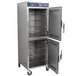 An Alto-Shaam stainless steel holding cabinet with two Dutch doors open and shelves inside.