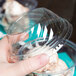 A hand holding a clear plastic Fabri-Kal sundae cup with ice cream in it.