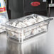 A clear plastic Cambro pan with food in it.