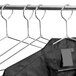 A black shirt hangs on a closed hook metal hanger.