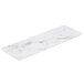 A white rectangular melamine serving board with a faux Carrara marble surface with black veins.
