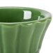 A close up of a green ceramic CAC Floral Ramekin with a wavy design.