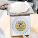 A person weighing white dough on an Edlund portion scale.