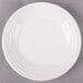 A white Fiesta luncheon plate on a gray surface.