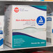 A box of Medique non-adherent absorbent pads on a shelf.