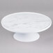 An Elite Global Solutions faux Carrara marble cake stand on a pedestal.