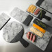 An Elite Global Solutions faux marble serving board with food on a table.