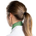 A woman wearing a seafoam green chef neckerchief with a ponytail.