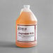A Noble Chemical 1 gallon bottle of heavy duty degreaser with orange liquid inside.