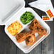 A Bare by Solo sugarcane take-out container with fried chicken, macaroni and cheese, and peas.