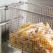 A Cecilware twin fryer basket filled with french fries on a counter.