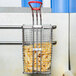 A Cecilware twin fryer basket filled with french fries.