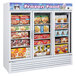 A Turbo Air white glass door merchandising freezer with shelves of frozen food.