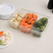 A Polar Pak clear plastic tray with carrots, broccoli, and food on a table.