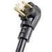 A close-up of a black power cord plug with two gold plugs.