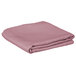 A folded pink table cover on a white background.