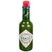 A close-up of a TABASCO green pepper hot sauce bottle with a green label and red cap.