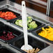 A white Cambro perforated spoon in a container of food on a salad bar.