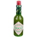 A close-up of a TABASCO® Green Pepper Hot Sauce bottle with a green label.