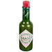 A close-up of a TABASCO Green Pepper Hot Sauce bottle with a green label and red cap.