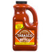 A 64 oz. bottle of TABASCO Buffalo Style Hot Sauce on a table.