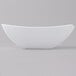 A white bowl with a curved edge on a white surface.
