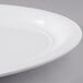 A close-up of a white Carlisle oval melamine platter with a rim.