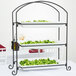 An American Metalcraft three-tier rectangular display stand with trays of broccoli on a table.