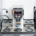 A Bunn automatic coffee brewer with stainless steel funnel sits on a counter.