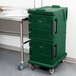 A green plastic Cambro Ultra Camcart food pan carrier on wheels.