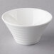 An Arcoroc white porcelain spiral appetizer bowl with a white rim on a gray surface.