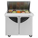 A Turbo Air refrigerated sandwich prep table with food trays filled with vegetables.