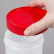 A hand holding a red lid on a Carlisle white plastic container.