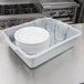 A gray Vollrath high density polyethylene bus tub with white plates and glasses in it.