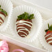 A white fluted baking cup filled with a chocolate covered strawberry.