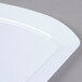 A close up of a white Fineline Wavetrends plastic plate with a curved edge.