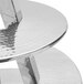 A silver stainless steel three tier display stand by American Metalcraft on a table.