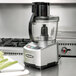 A Waring food processor with an S blade on a counter.