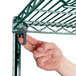 A hand using a screw to assemble a Metro Super Erecta wire shelving unit.
