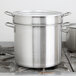 A Vollrath stainless steel double boiler sitting on a stove.