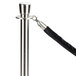 A black stanchion rope with satin silver ends attached to a pole.