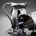 An American Metalcraft silver pitcher with ice cubes.